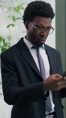 Afro-Amerikalı işadamı hayal kırıklığına uğramış cep telefonunu rahatsız eden, sohbet eden akıllı telefon iş adamı cep telefonu tutan, elinde negatif haber arızası olan bir adam.