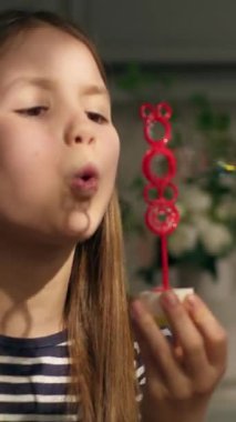 Küçük beyaz kız çocuk bebek bebek evde sabun köpüğü üflüyor oyuncakla eğleniyor sabun köpüğü oynuyor mutlu çocukluk anıları aile dairesinde.