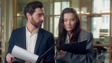 Çok ırklı ofis çalışanları, Beyaz iş adamı Koreli iş adamlarıyla evrak sözleşmesi yapıyor. Çizelge belgelerini tartışıyorlar.