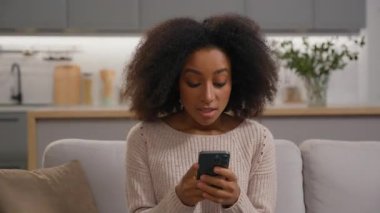 Heyecanlı sürpriz kazanan mutlu Afro-Amerikalı kadın bağırışlarını cep telefonuyla kutluyor şanslı bayan kız iyi haberleri okuyarak zafer kazanıyor akıllı telefon fırsatıyla bahis yaparak.