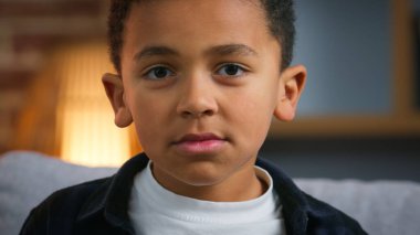 Evdeki ciddi Afrikalı Amerikalı çocuğun portresi. Kamera, etnik oğul, çocuk, liseli çocuk, üzgün. Bakış, aile, çocuk bakımı, çocuk bakımı, çocuk bakımı gibi konular.