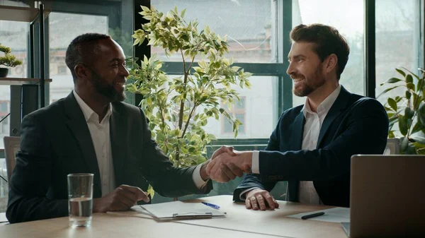 Çok ırklı iş adamları anlaşma imzaladı. Yatırım anlaşması imzaladı. İki farklı etnik erkek takım çalışması.