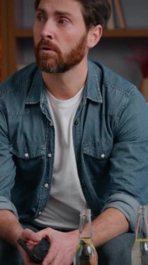 Beyaz, orta yaşlı, hayal kırıklığına uğramış bir adam pizza cipsi ile iptal edildi. Yalnız, yalnız, erkek adam kanepenin üzerinde yalnız, yalnız, kimsesiz doğum gününde yalnızlık karantinada acı çekiyor.