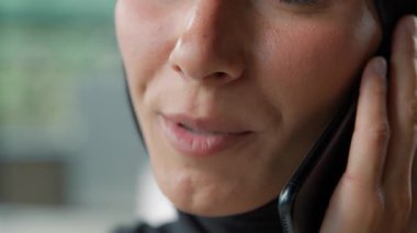 Yakın planda tanınmayan Arap Müslüman iş kadını tesettürlü cep telefonlu mutlu İslamcı iş kadını ağzı akıllı telefon kızıyla konuşuyor iş görüşmelerini tartışıyorlar