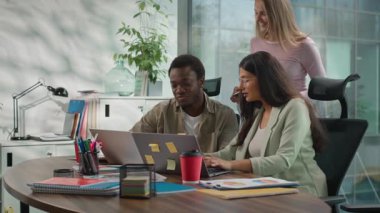 Çok ırklı Gayri resmi Girişim Ofisi. Afrikalı işadamı ve Hintli iş kadını. Bilgisayarda dijital tablet gösteren Kafkasyalı CEO kadın geliyor.