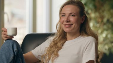 Rahatlamış, mutlu, Kafkasyalı bir kadın kahvesini yudumluyor sabah dinleniyor kadın iş kadını, serbest kahvesini içiyor çay içiyor ev hanımı el ele tutuşuyor bardak içkisi içiyor evinde huzurlu bir an yaşıyor.