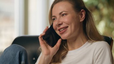 Gülümseyen Kafkasyalı kadın cep telefonundan konuşuyor akıllı telefondan konuşan mutlu iş kadını müşteri cevap ver cep telefonu teslimatı ev içi iş konuşmaları