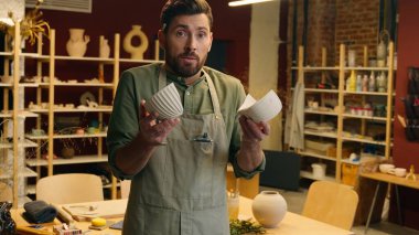 Korkan Kafkasyalı iş adamı erkek işadamı çömlekçi seramik satıcısı el ele tutuşan vazo porselen çanak çanak çömlek sanatı fotoğrafçısı kamera görüntüsü seramik mağaza şoku