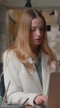 Portre işi yapan kadın iş kadını. İnternette bilgisayarını karıştırıyor. Ofisteki müşterilerle sohbet ediyor.