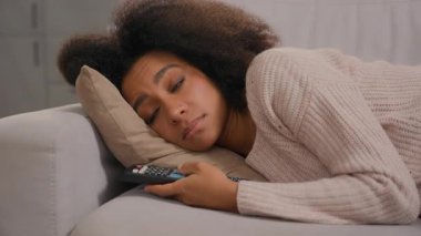 Afro-Amerikalı yorgun kadın kendini kötü hissediyor. Kanepede uzanmış, elinde uzaktan kumandayla televizyon seyrediyor. Evde hayal kırıklığına uğramış duyguları tükenmiş bir kadın.