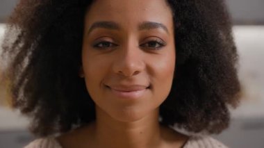 Yakın plan Afro-Amerikan kızı gülümseyen dişlek, sağlıklı, dişlek, dişlek, mutlu, etnik, neşeli kadın gülümseyerek kameraya bakıyor doğal, kıvırcık saçlı portre.