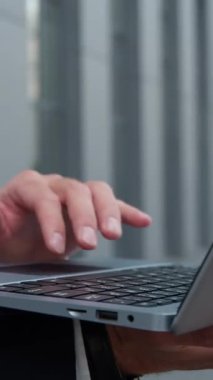 Yakından erkek, tanınmayan iş adamı şehirde bilinmeyen bir iş adamının bilgisayarında daktilo yazıyor. Kablosuz bilgisayar bilgisayarı klavye yöneticisi ile sohbet ediyor. Açık havada çalışan erkek çalışan, e-posta iletişimini kontrol ediyor.