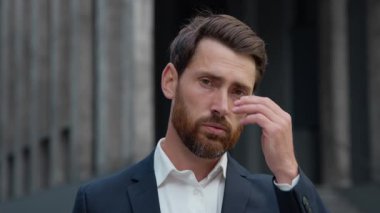 Kafası çalışan Kafkas bir iş adamı orta yaşlı bir iş adamı migren ağrısı çeken kameraya bakarken yorgun ve kötü hisseden bir girişimci yönetici.