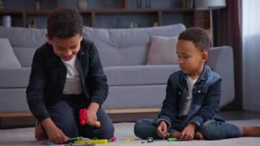 İki Afro-Amerikalı çocuk evde plastik oyuncaklarla oynuyorlar. erkek kardeşler erkek kardeşler erkek kardeşler arkadaşlar arkadaşlar çekiç dostluğu ile oyun oynuyorlar çocukluk zamanı