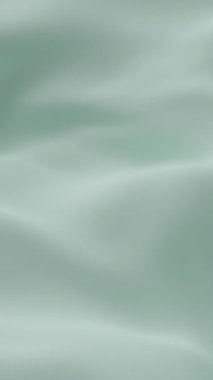 Yumuşak nane yeşili ipek kumaş yumuşak dalgalar oluşturarak zarif minimum arkaplan dokusu yaratarak tazeliği, sakinliği ve tasarım, video veya dekor temaları için lüks estetiği sembolize eder.