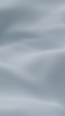 Yumuşak mavi ipek kumaş yumuşak dalgalar oluşturarak zarif minimum arkaplan dokusu yaratarak tazeliği, sakinliği ve tasarım, video veya dekor temaları için lüks estetiği sembolize eder.