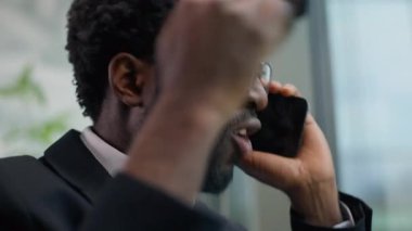 Öfkeli Afrikalı Amerikalı iş adamı ofiste konuşan erkek işadamı cep telefonu tartışması olumsuz öfkeli telefon konuşması çığlıklar atan, kötü pazarlık iletişimi.
