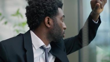 Endişeli Afrikalı Amerikalı erkek iş adamı erkek işadamı düşünme çözümünü vurguladı ofis sorununda cam eğimli cam aldı iş stresi iş stresi iş başarısızlığına karar verdi
