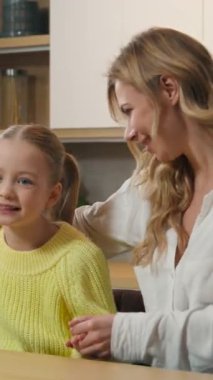 Kafkasyalı mutlu aile mutfakta dans ediyor kaygısız çocuk annesi mutfakta yemek masasında birlikte eğleniyor annesi kızı kucağında kucağında müzik eşliğinde dans ediyor kollarıyla sevinçle hareket ediyor