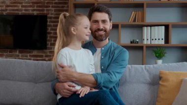 Kafkas mutlu bir aile oturma odasında kız ve baba kucaklaşıyorlar gülümsüyorlar kameraya bakıyorlar sevimli çocuk çocuğa sarılıyorlar neşeli babalar günü velayetinde kucaklaşıyorlar