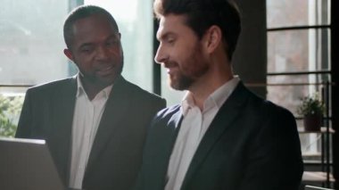 İki farklı adam, çok ırklı iş adamları, iş adamları ve beyaz iş adamları, dijital yatırım konusunda Afrikalı Amerikalı yatırımcıya danışıyorlar.