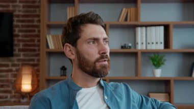 Kafkasyalı orta yaşlı bir adam kameraya bakıp gülümsüyor mutlu, olgun bir erkek ev sahibi kendi kira evinde dinleniyor ev kredisini yatırıyor.