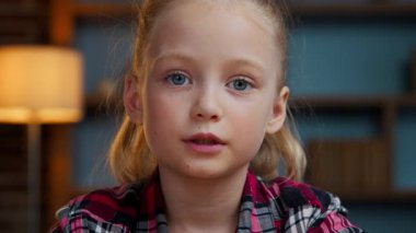 Portre web kamerası görüntüsü Kafkasyalı şirin kız çocuğu video kamera görüntülerine bakıyor. Web kamerası deniyor. İletişim, küçük kız sohbeti, internette akşam evde sanal sohbet.