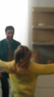 Mutfakta mutlu bir aile sabah vakti küçük bir kız babasına koşuyor çocuk yetiştiren bir kız çocuğu dönüşümlü etrafında dönüyor kucaklaşıyor dokunuyor burunlarına dokunuyor sevgi dolu velayet bağlılığı.