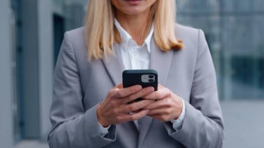 Yakın plan tanınmayan beyaz iş kadını şehir merkezindeki iş kadınında cep telefonuyla sohbet ediyor akıllı telefon şirketleriyle sohbet ediyor e-postaları kontrol ediyor şehir merkezindeki internet kullanan kadın işverenleri kontrol ediyor.