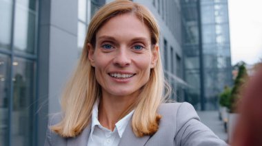 İnternet kamerası, beyaz ırktan orta yaşlı bir iş kadınının şehir merkezindeki konferansta konuşan iş kadınıyla yakın plan görüntüsü.