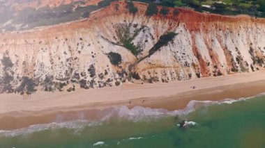 Algarve Portekiz kıyı şeridi gezisinin üst hava aracı görüntüsü. Kızıl kayalıklar, kumlu sahil, Atlantik Okyanusu, yaz seyahati. Avrupa, tatil, doğa, Portekiz, tarihi bölge.
