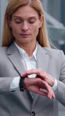 Ciddi, beyaz, orta yaşlı bir iş kadını. Kol saatiyle şehri kolaçan ediyor. Yetişkin iş kadını kadın yönetici girişimciyle buluşmayı bekliyor.