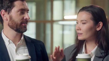 Kafkasyalı mutlu iş adamlarını kapat kahve molası ver sohbet et iş arkadaşları iş arkadaşları neşeli erkek kadın iş kadını konuş içki fincanı çayı iç rahatla