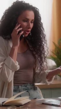 Stresli İspanyol iş kadını cep telefonu anlaşmazlığı hakkında konuşuyor dizüstü bilgisayarla notlar yazıyor tartışmalar, tartışmalar, tartışmalar, tartışmalar, tartışmalar, tartışmalar, ev bilgisayarları, Latin kadın iş kadını, serbest mutfak çalışanı.