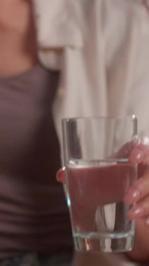 Mutlu İspanyol kadın cam suyu içiyor. Mutfak kadınlarına gülümsüyor. Kızların göz kırpmasından keyif alıyor.