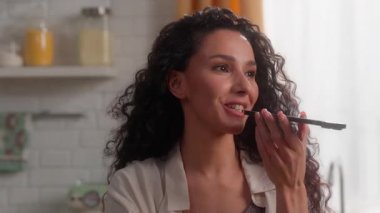 Mutlu gülümseyen İspanyol iş kadını ses mesajı kaydediyor ev mutfağında cep telefonu konuşuyor Latin Kafkas kadın iş kadını mikrofon konuşma akıllı telefon ses komutu çevrimiçi uygulama kızı