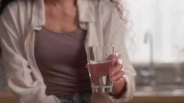 Mutlu İspanyol kadın cam suyu içiyor. Mutfak kadınlarına gülümsüyor. Kızların göz kırpmasından keyif alıyor.