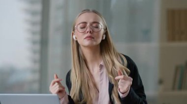 Kablosuz kulaklıkla müzik dinleyen Kafkasyalı iş kadını. Kapalı gözlerle müzik dinliyor, dinlendirici iş molası veriyor. Laptop dansı yapan iş kadını.