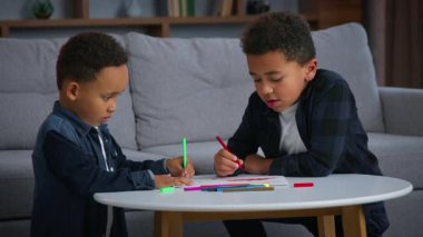 İki etnik Afrikalı Amerikalı çocuk resim çizerek eğleniyor. Öğrenciler, çocuklar, aile bireyleri, kardeşler. Birlikte sanat terapisi ödevleriyle meşguller.