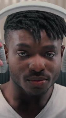 Kulaklık takan, kulaklık takan, dizüstü bilgisayar kullanan, modern fütürizm yenilikçiliği teknolojisi kullanan, kulaklık takan, kulaklık takan, bilgisayar kullanan, fütüristik servislerde oynamaya başlayan Afro-Amerikalı bir adam.