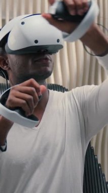 VR başlıklı Afro-Amerikan adam sanal gerçekliği kullanarak fütüristik uzay kontrolörleri el ele tutuşuyor hologramları havada hareket ettiriyor modern teknolojide yenilikçi erkek adam fütüristik oyun metaevreleri oynuyor.
