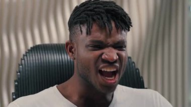 Saldırgan Afrikalı Amerikalı adam fütüristik odada öfkeli bağırıyor gergin erkek oyuncu duygusal tepki kaybediyor çığlık çığlığa bağırıyor.