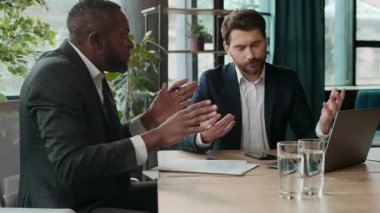 İki adam sinirli tartışmalar yapan farklı iş adamları tartışır. İş adamları iş yerinde dizüstü bilgisayarla tartışır. Beyaz Afrikalı Afrikalı Amerikalı meslektaşlar hata yapar.