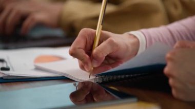 Kapalı mekânlarda çalışan çok ırklı iş adamlarını kapatın. Asyalı adam, Koreli iş adamı dizüstü bilgisayarı daktilo ediyor. Müşterilerle sohbet ediyor.