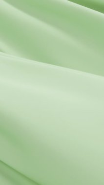 Yumuşak yeşil kumaş hafifçe sallanıyor zarif minimal arkaplan oluşturuyor nazik kıvrımlar akış dokusu berraklığı hareketsiz yüzey saflığı tasarımı uyumu soyut görsel yumuşaklık arka planı