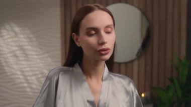 Gülümseyen kadın banyoda dans ediyor müziğin tadını çıkarıyor cilt bakımı güzellik sabah rutini neşeli beyaz kız portresi kozmetik krem sürüyor cilt bakımı mutluluğu