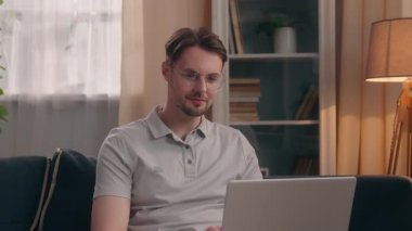 Evde dizüstü bilgisayarda çalışan, İspanyol kadına sarılan, erkek, serbest çalışan, kadın, çoklu etnik çiftleri seven, kapalı bir evde oyun oynayan, sevgi dolu, rahat bir oturma odasında sarılan beyaz bir adam.