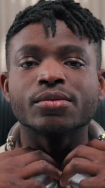 Afro-Amerikalı erkek adam kulaklık takıyor, müzik dinliyor, gözleri kapalı sakin sakin sakin dinleniyor, fütürizm teknolojisinin tadını çıkarmak için fütüristik uzay stüdyosunda arkasına yaslanıyor.