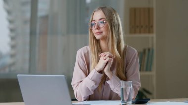 Kafkasyalı mutlu iş kadını, dizüstü bilgisayarı ve bir bardak suyla ofis çalışanı bayan iş kadınına gülümsüyor, içki içiyor, gülümsüyor, sağlıklı bir yönetici, kapalı alanda çalışıyor.