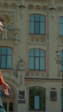 Üniversitenin dışında buluşan üç çok ırklı öğrenci sınıf arkadaşlarına sarılıyorlar sınıf arkadaşları dersine birlikte gidiyorlar erkek adam, beyaz Afrikalı kadın kızlar koleje gidiyor.